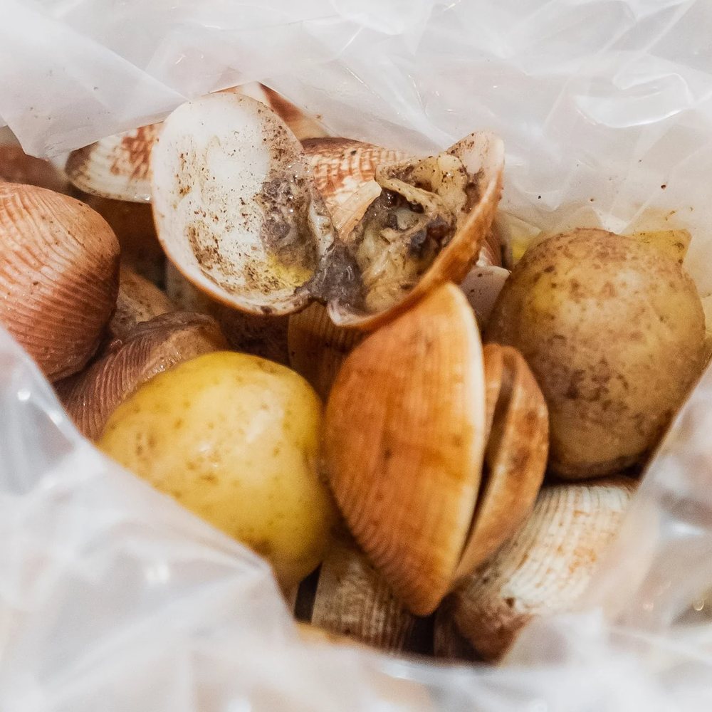 A bag of boiled clams with baby potatoes